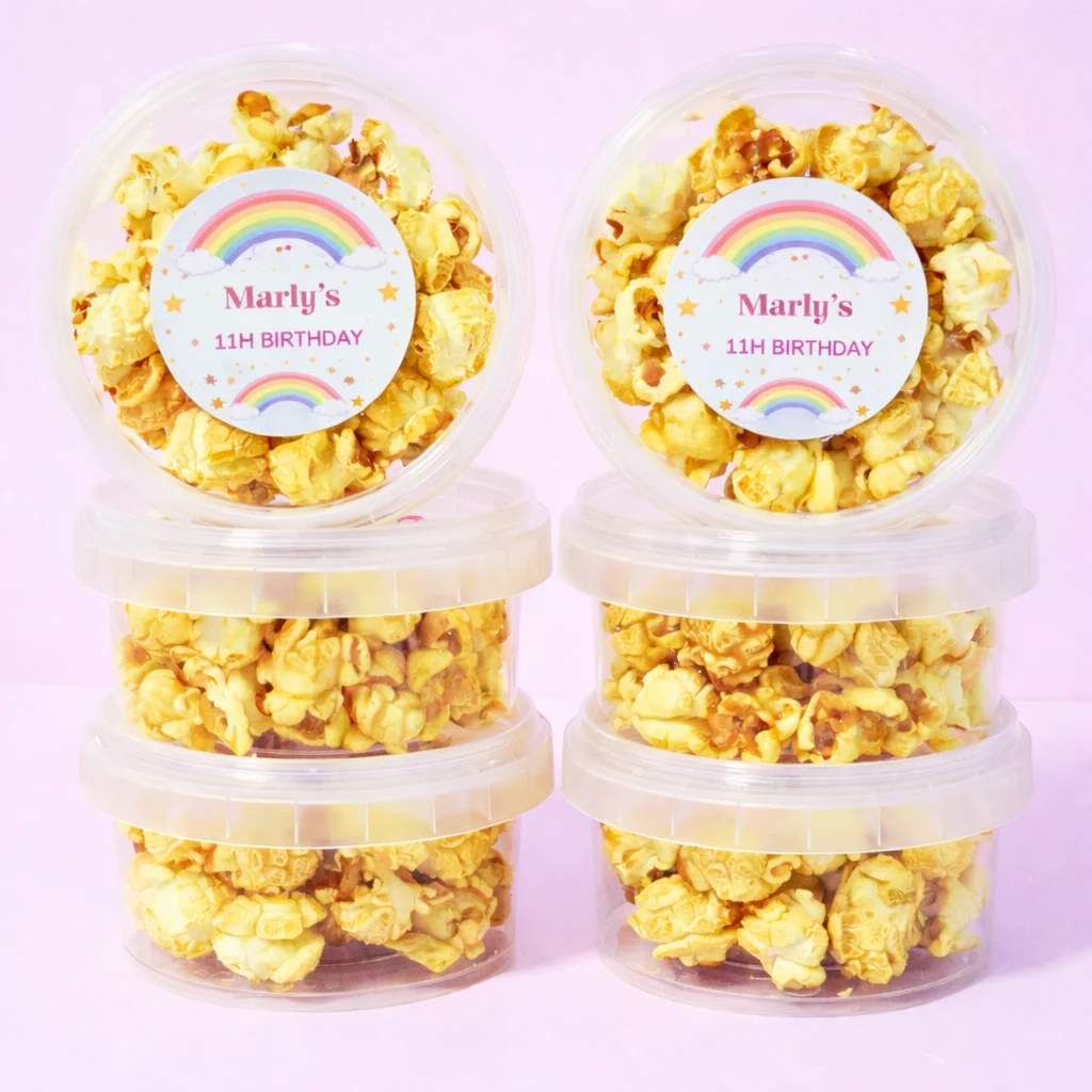 Caramel popcorn tubs with personalised labels for party orders