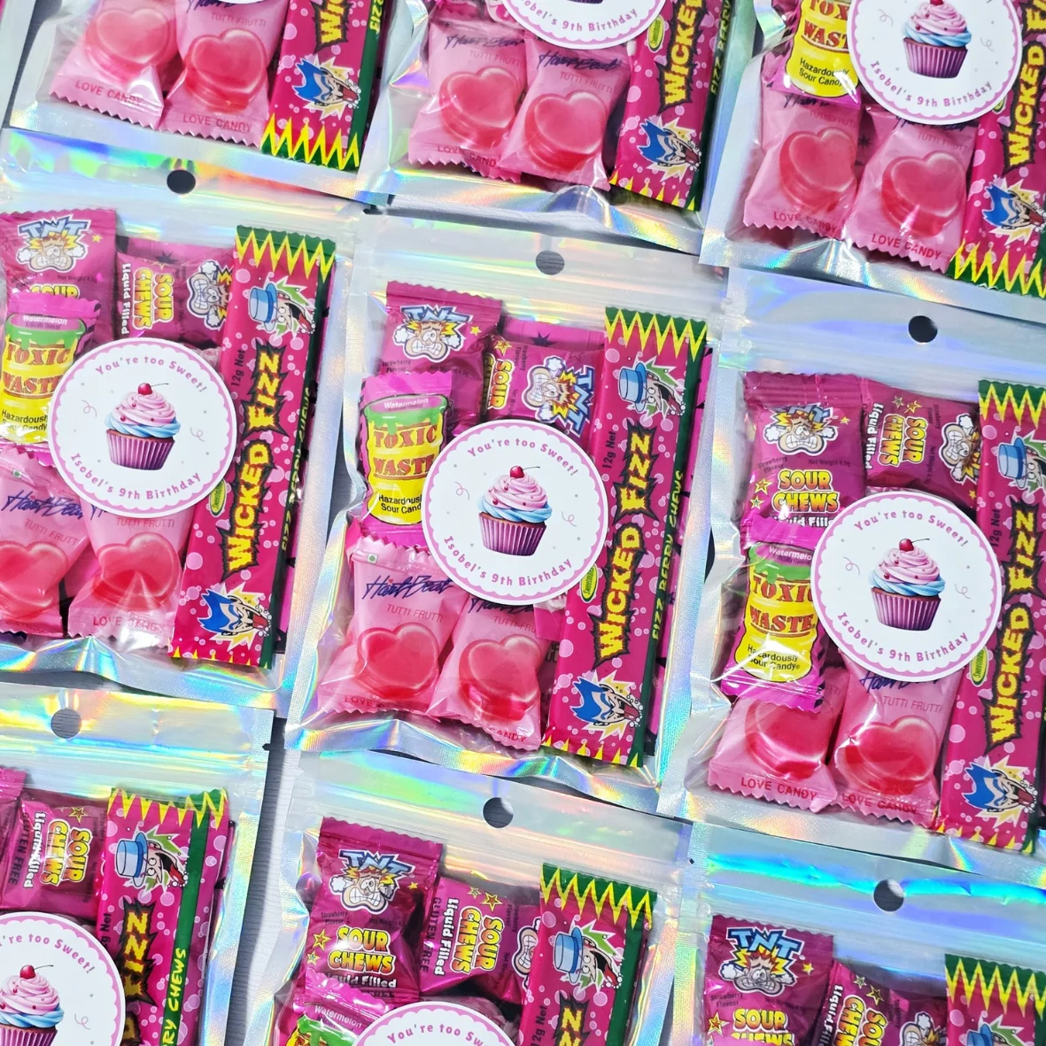 Personalised kids lolly party bags filled with colourful candies and custom birthday labels.