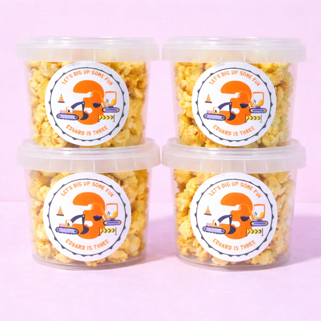 Personalised caramel popcorn tubs with construction birthday labels
