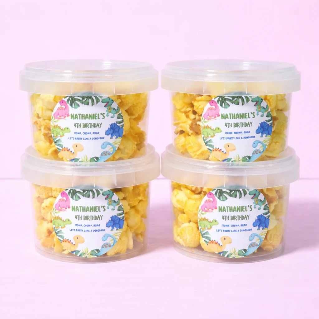 Personalised caramel popcorn tubs with dinosaur birthday labels
