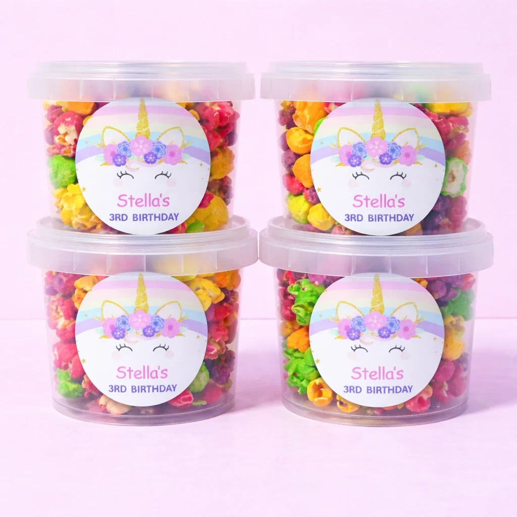 Personalised rainbow popcorn tubs with unicorn birthday labels