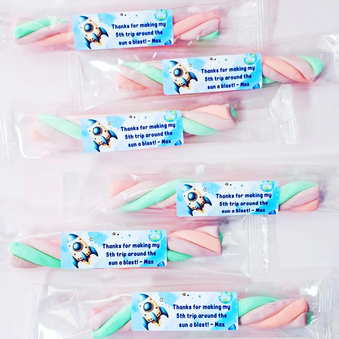 Space themed marshmallow twist party favours with rocket label personalised for a kids birthday party.