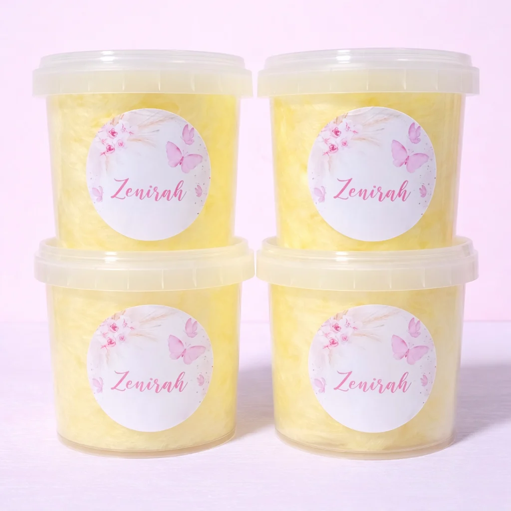 Butterfly themed personalised fairy floss party favours in yellow tubs with soft pink floral design, perfect for girls birthday parties and elegant celebrations