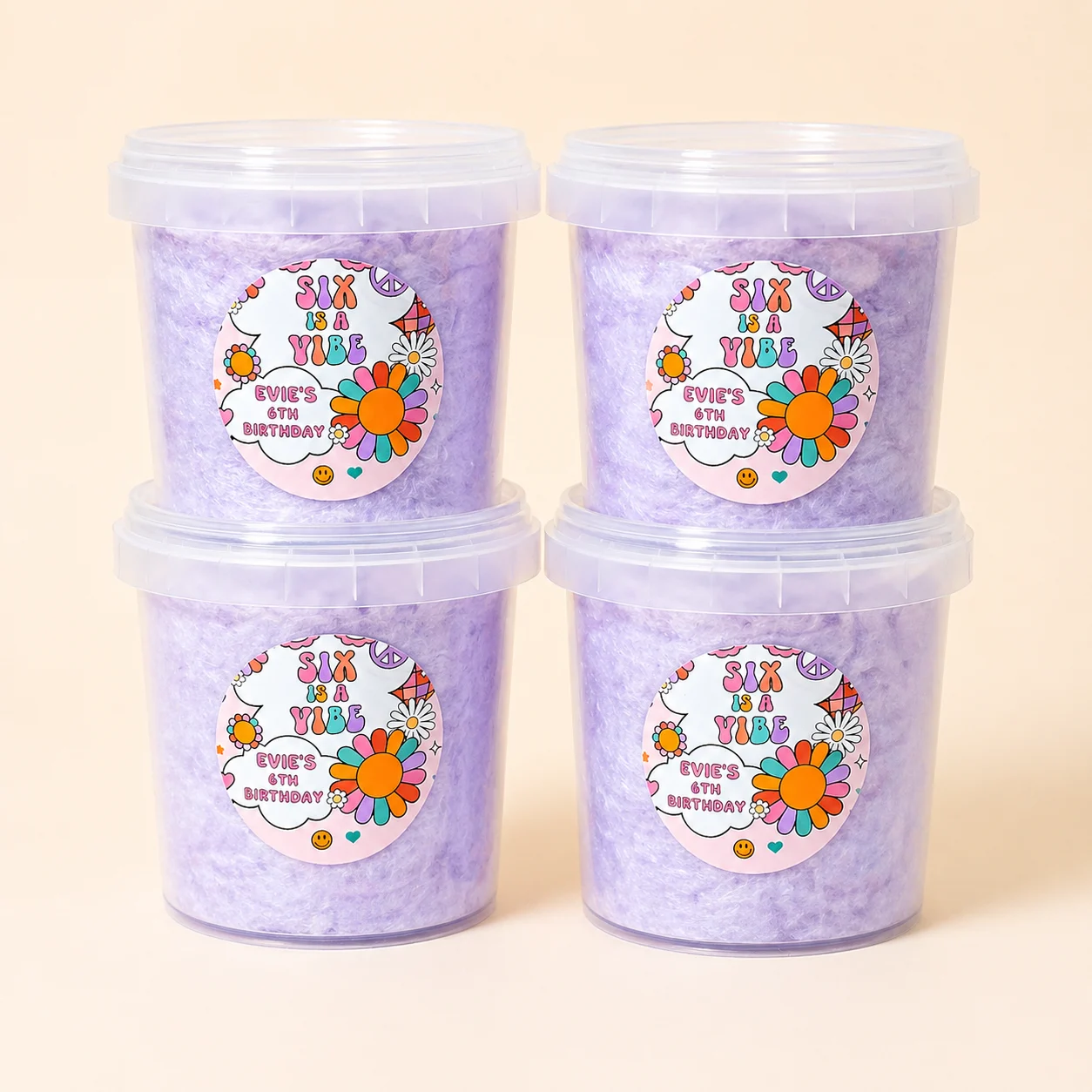 Retro “Six is a Vibe” groovy themed personalised fairy floss party favours in purple tubs with colourful floral design, customised for birthday celebration